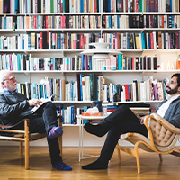 two men conversing in a library