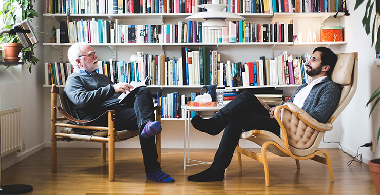 two men conversing in a library