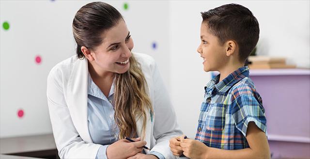 psychologist and little boy smiling at each other