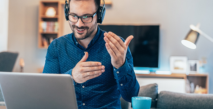 Man with headphone on interacting with laptop