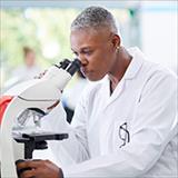 female scientist peering into microscope