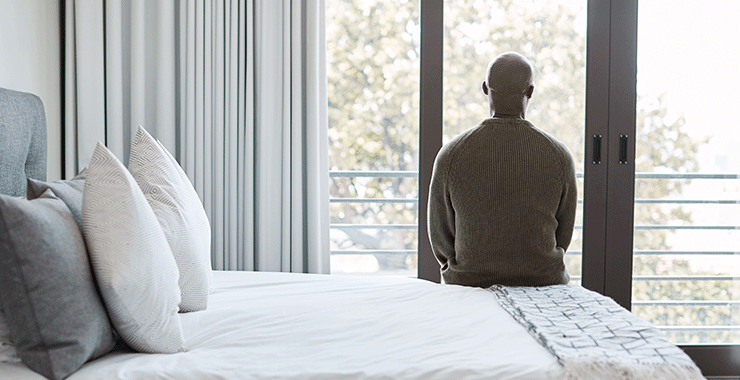 man sitting alone on a bed