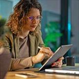 Woman in an office setting looking at her tablet