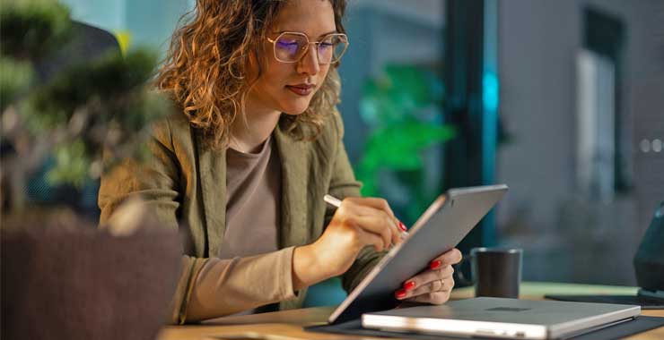Woman in an office setting looking at her tablet