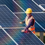 Worker who is adjusting a giant solar panel