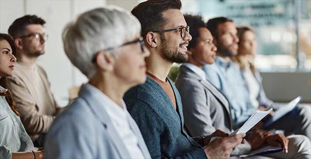 people listening to a conference presentation