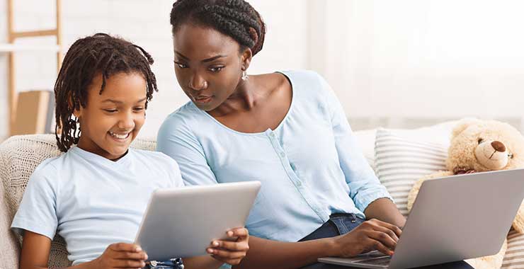 Mother and young son looking at his tablet