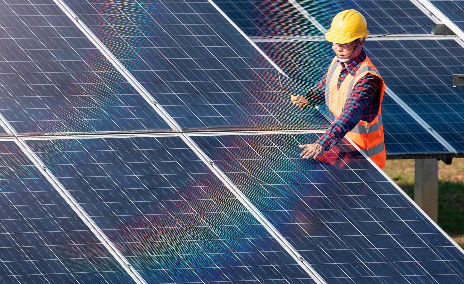 A worker who is adjusting giant solar panels. 