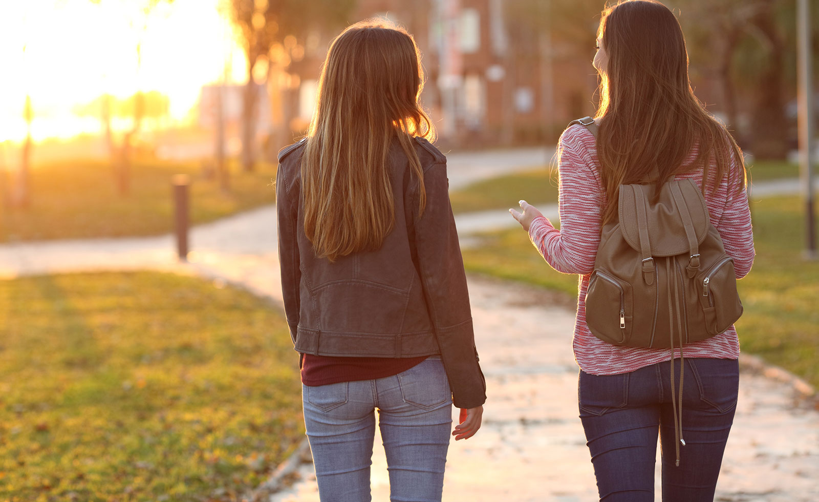 Two females on a college campus walking and talking