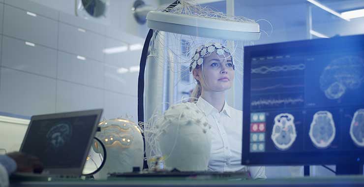 Scientist examining brainwave scanning headset in laboratory