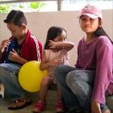Young children sitting on the ground in a parking lot