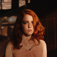 A female in the shadow with a worried facial expression