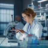 Researchers use microscopes and laboratory equipment while conducting scientific research in a laboratory.