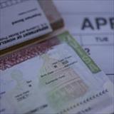 Close-up of an H-1B visa document and paperwork placed on a calendar.