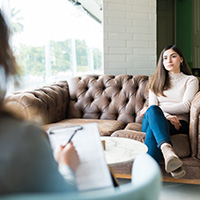 Woman speaking with a psychologists who is taking notes