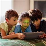 Three kids looking at a tablet