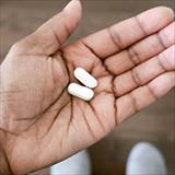Hand holding two pills