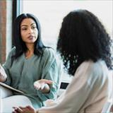 A woman is engaged in a conversation with a mental health expert