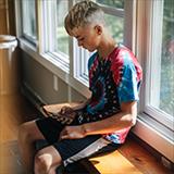 teenage boy looking on his phone in a classroom