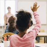 child raising hand in classroom