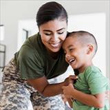 woman wearing military fatigues tickling a young boy