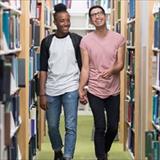 Two young man walking in library aisle