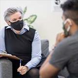 Masked woman holding clipboard