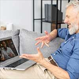 Middle-aged man using his laptop to engage in a video call with a health professional