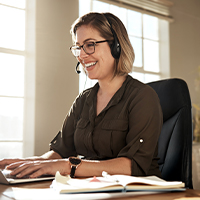 smiling person sitting at portable computer