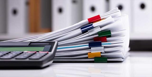 stack of paperwork and calculator