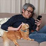Man with his cat looking at smartphone 