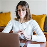 Female student looking at her laptop at home