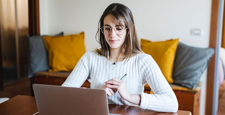 Female student looking at her laptop at home