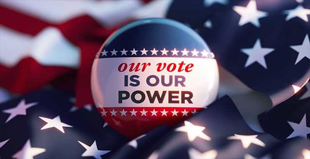button saying “Our vote is our power” on top of U.S. flag
