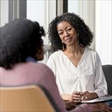 two black women talking in a professional settiing.