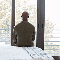 man sitting alone on a bed