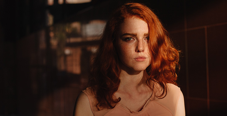 A female in the shadow with a worried facial expression