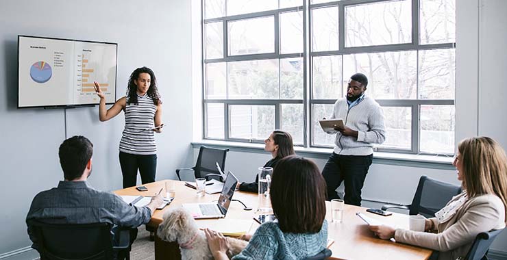Employees in meeting viewing graphs