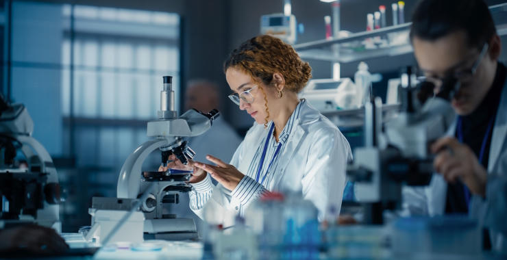 Researchers use microscopes and laboratory equipment while conducting scientific research in a laboratory.