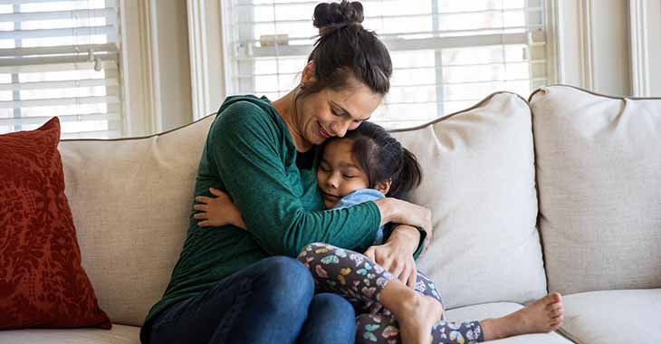 Mom and daughter hugging on couch