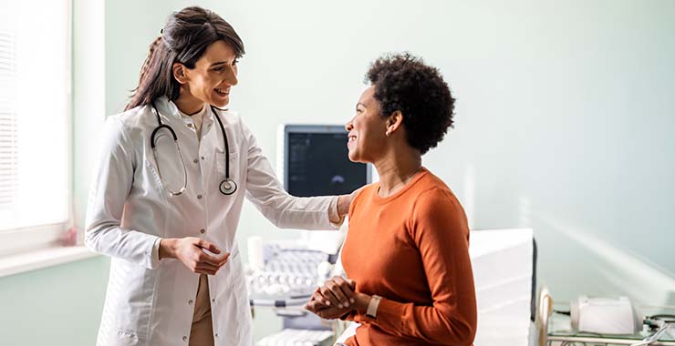 A doctor and patient smiling at each other