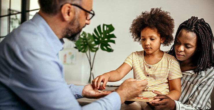 Black mother and daughter interacting with psychologist