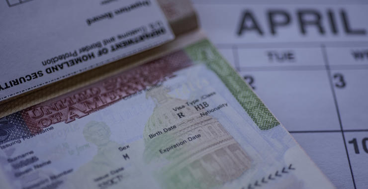 Close-up of an H-1B visa document and paperwork placed on a calendar.