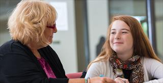 Teacher and student smiling at one another