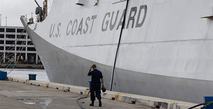 Man walking beside U.S. Coast Guard ship