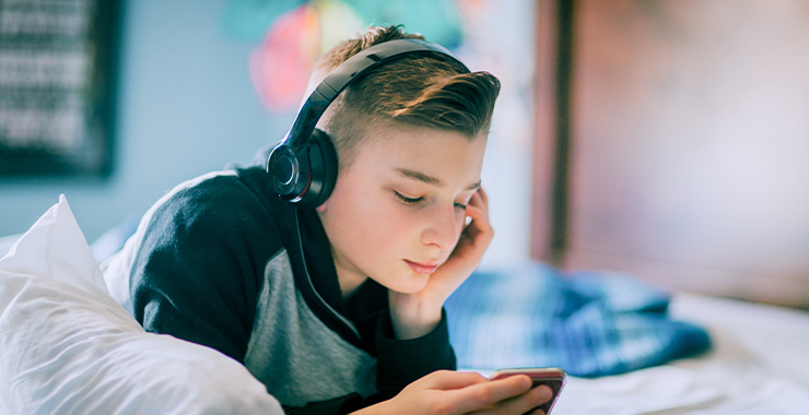 Boy in his room looking at his cellphone