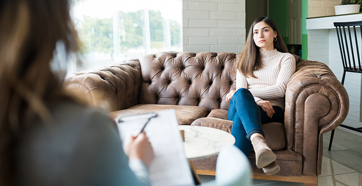Woman speaking with a psychologists who is taking notes