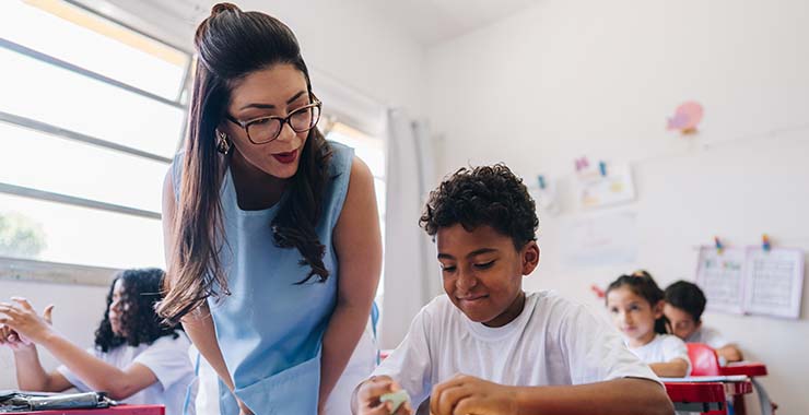 A teacher assisting a student with work in a classroom