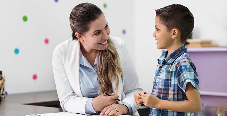 Teacher and student happily conversing in a classroom environment