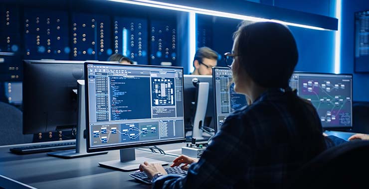 Employees using computers in a server room